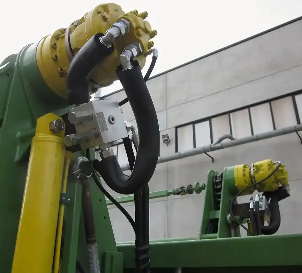 Macchinario industriale con tubazioni e componenti idraulici verdi e gialli.